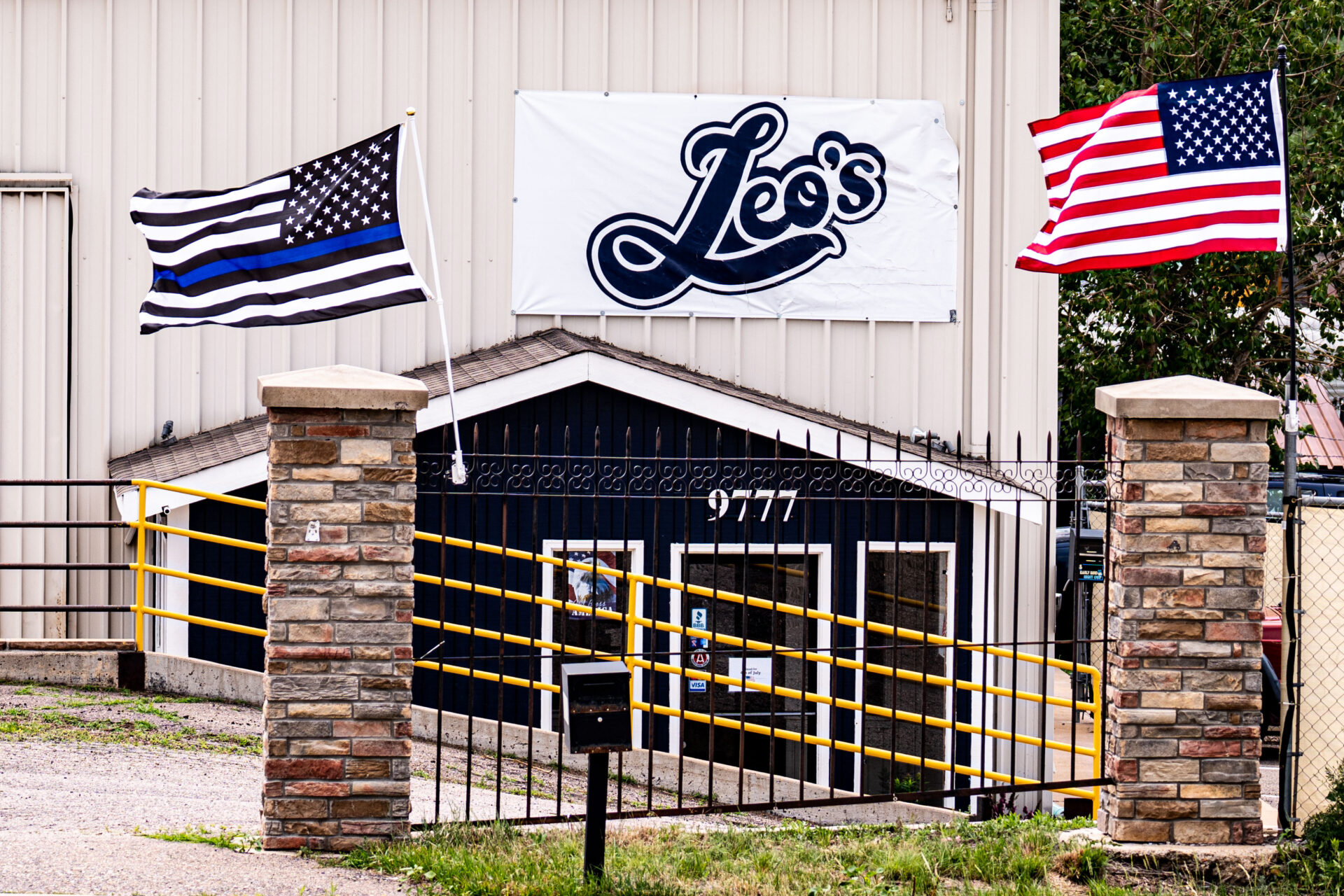 exterior view of the front side of Leo's Auto Body auto shop building in Littleton
