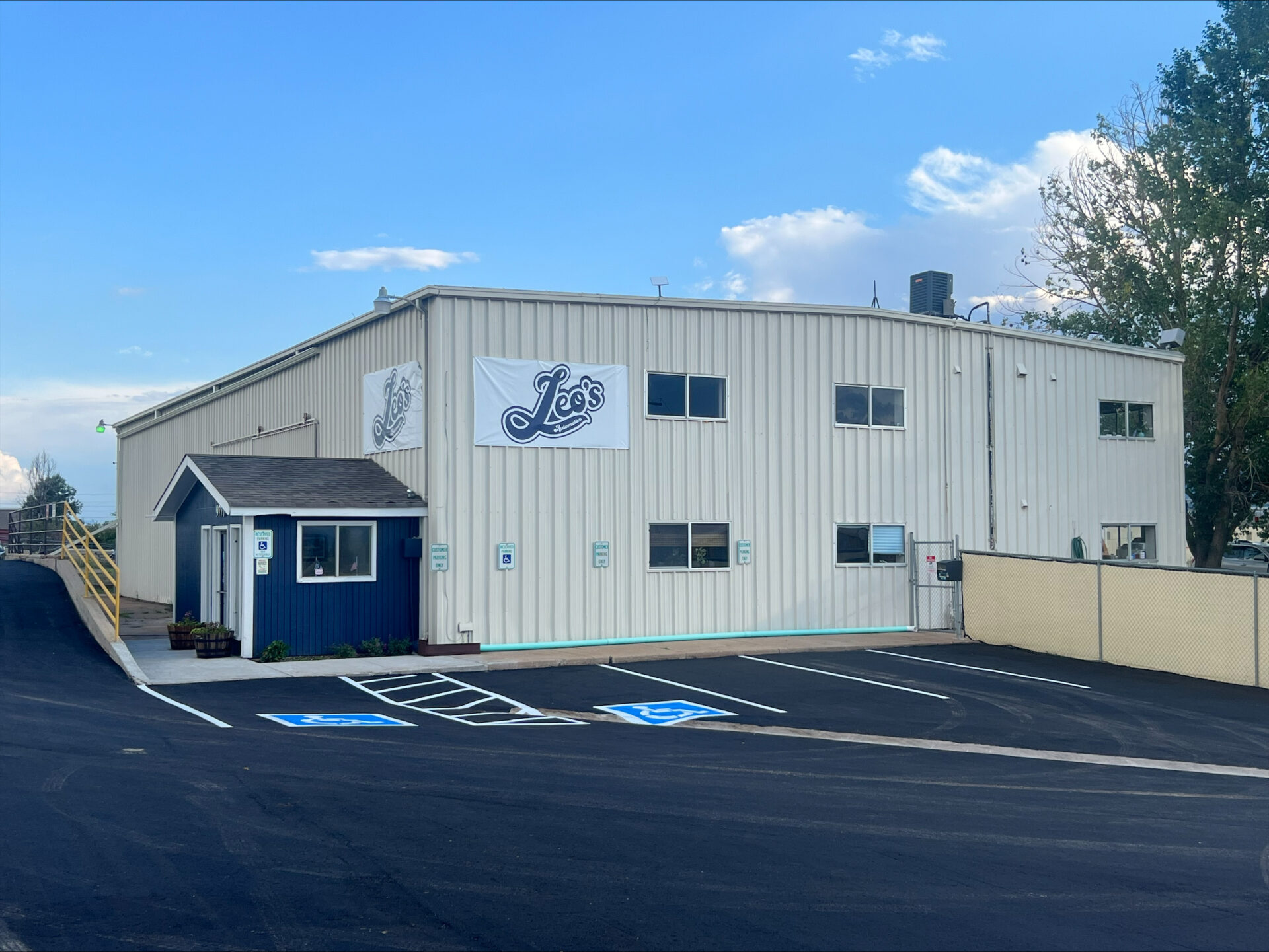 exterior view of Leo's Auto Body shop and parking lot
